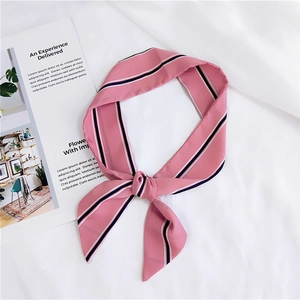 Detail of pink striped silk scarf showing soft texture and elegant knot on white cloth