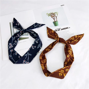 Close-up of floral chiffon hair ribbons in navy and brown on a vintage magazine