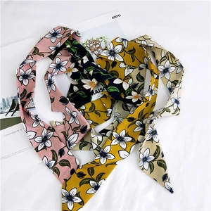 Detail view of colorful floral pattern scarves in pink, black, yellow, and beige styles