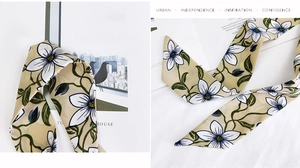 Detail of floral chiffon scarf with white petals on beige fabric used as a hair ribbon