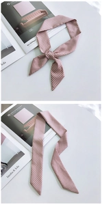 Detailed close-up of pink and white polka dot silk scarf tied as a fashion accessory