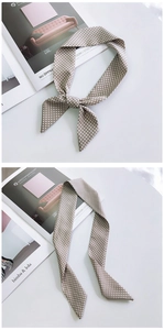Detailed view of polka dot silk scarf tied in a bow on a minimalist stylish background