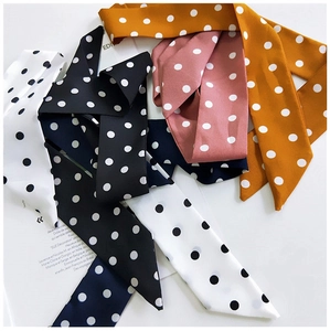 Polka dot silk scarves in multiple colors layered on a French fashion magazine page