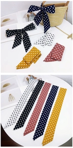 Close-up of polka dot skinny scarves tied on a straw bag and flat lay color options