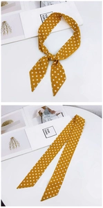 Detailed view of yellow polka dot narrow silk scarf used as a stylish hair tie or bag accessory