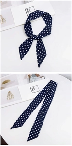 Detail of navy blue polka dot silk scarf tied on a handle with elegant diagonal ends