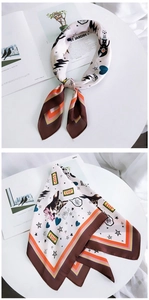 Detail of a square satin scarf with cartoon dog prints and colorful striped edges