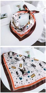 Detail of silk square scarf featuring cartoon French Bulldog pattern and satin texture