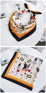 Detail of square silk scarf featuring cartoon dog prints and geometric striped edges
