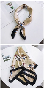 Detailed view of champagne silk square scarf with circus prints and black borders