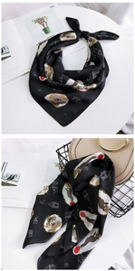 Detail showing circus theme silk scarf tied on a beige bag and styled on white table