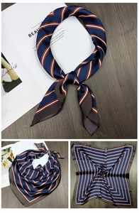 Detail of navy blue and rust red striped silk-feel square scarf on wooden background