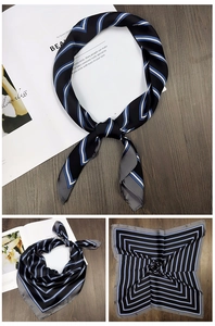 Close-up of geometric pattern silk scarf with sleek finish and elegant dark navy borders