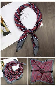 Detail showing the burgundy and blue striped silk scarf folded on a magazine
