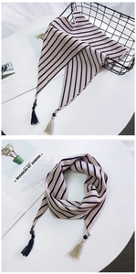 Détail d'un foulard en soie rayé avec perles en bois et glands bicolores de style moderne