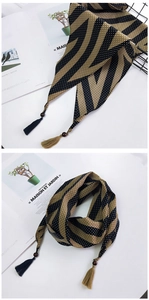 Détail d'un foulard en soie à pois bleus et rayures avec perles en bois et pompons