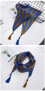 Détail de foulard en soie avec motifs de vagues bleues, perles en bois et pompons