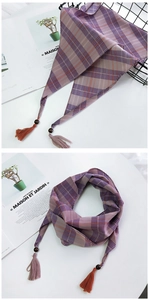 Détail d'un foulard en soie à carreaux violets avec perle en bois et glands colorés