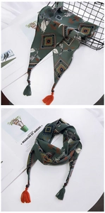 Détail d'un foulard bohème avec motifs géométriques de plumes et pompons bicolores élégants