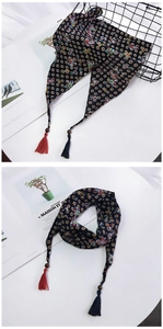 Détail de foulard à motif cachemire avec perles en bois et glands bicolores