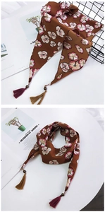 Détail d'un foulard à fleurs avec perles en bois décoratives et pompons à franges