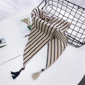 Petit foulard rayé avec perles en bois et glands sur un fond de style minimaliste