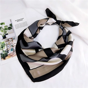 Close-up of geometric silk-feel scarf tied in a knot showing smooth texture and colors