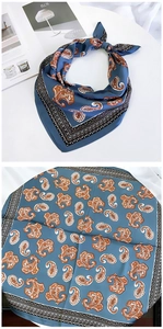 Macro detail of silk paisley square scarf in blue and orange with geometric border