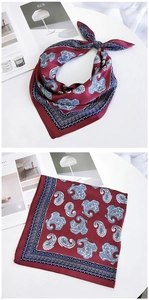 Detailed close-up of a burgundy paisley silk square scarf with vintage patterns