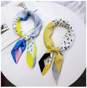 Detail view of two colorful geometric pattern twilly silk scarves for professional styling