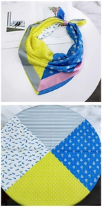 Detail of a floral square silk scarf showing multicolor patchwork patterns and silky texture