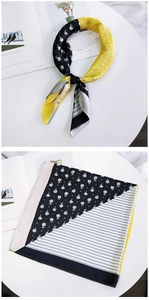 Detail of silk square scarf featuring yellow floral and striped patterns for women