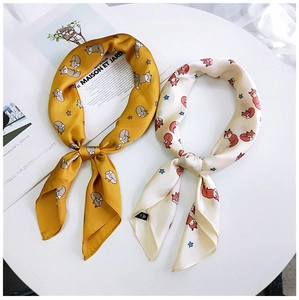 Détail d'un foulard en soie avec motifs de renard et d'étoiles en jaune et crème