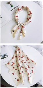 Détail d'un foulard en soie avec motif renard rouge et étoiles bleues sur satin beige