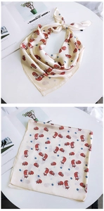 Détail d'un foulard carré en soie avec renards rouges et étoiles bleues sur fond beige
