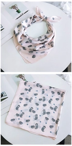 Détail d'un foulard en soie rose avec motifs de renard et d'étoiles bleues sur blanc