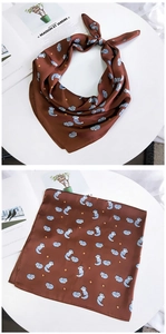 Détail d'un carré de soie marron avec motifs de renard et finition satinée