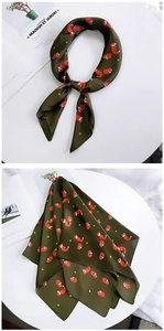Vue détaillée du foulard en soie vert foncé avec imprimé renard orange autour du cou