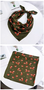 Détail d'un foulard carré en satin vert foncé avec motifs de renards et d'étoiles