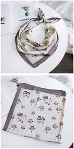Détail d'un foulard carré en satin avec motifs de chouettes et bordures lilas