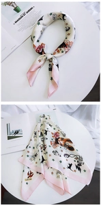 Detail of a chic silk scarf featuring astronaut and rabbit prints with pink borders