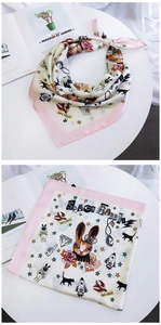 Detail of square silk scarf featuring space rabbit cartoon print and pink border edge