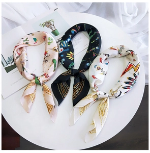 Detailed view of chic printed silk scarves featuring pink, black, and white patterns