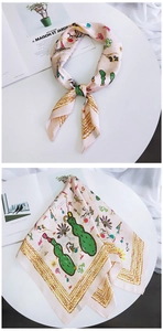 Pink chic square silk scarf with cactus and deer illustration styled on a magazine