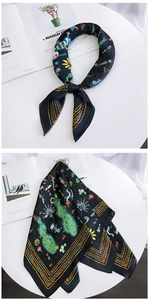 Close-up of black satin scarf with colorful animal prints and gold wavy edges