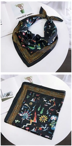 Detail of silk-like scarf featuring colorful cartoon patterns and golden wavy borders