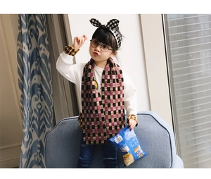 Detailed view of kids' purple and ginger checkered scarf with matching plaid bow headband