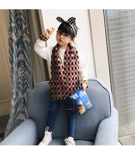 Detailed shot of pink plaid children scarf and matching bunny ear headband on a toddler