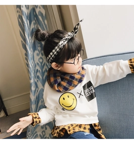 Detail of children's white sweatshirt with yellow smiley face and blue plaid scarf set