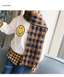 Close-up of thick blue and orange plaid scarf paired with a white smiley sweatshirt